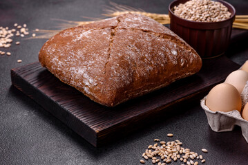 Beautiful tasty, square-shaped brown bread on a dark concrete background