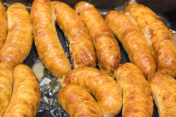 fried homemade rustic sausages close-up as background