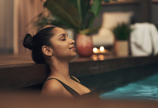 No interruptions... just me and my thoughts. Shot of a young woman relaxing in a pool at a spa.