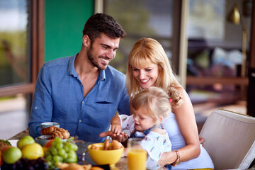 Obraz premium Family with daughter having breakfast