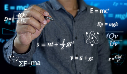 A math or physics teacher holds a pen in his hand to write complex mathematical equations on a...
