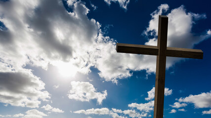 Jesus Christ cross. Easter, resurrection concept. Christian wooden cross on a background with dramatic lighting, colorful mountain sunset, dark clouds and sky, sunbeams.
