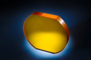A glass object lying on a black surface, painted in different colors. Multicolored glass object....