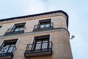 Obraz premium Low angle view of old cast iron balconies of old residential building in Lavapies quarter in Madrid