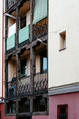 Fototapeta na wymiar Low angle view of old cast iron balconies of old residential building in Lavapies quarter in Madrid