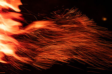 Beautiful campfire flame sparks shooted in motion and isolated on black background