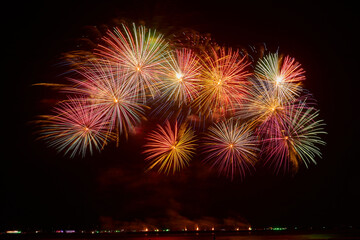 Color flashes of fireworks against the black sky.