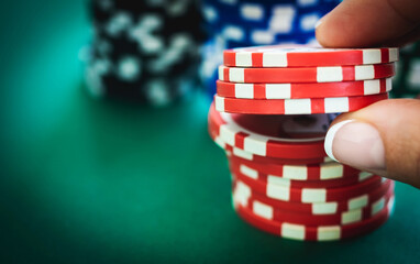 Stack of red casino chips and gambler hand