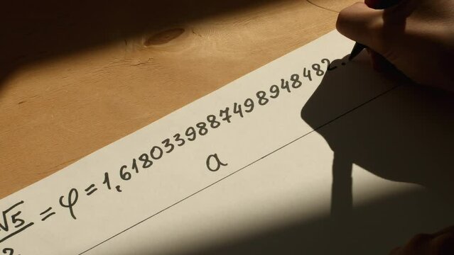Young mathematician hand writes number Phi on the paper. Date of shooting day 23 March 2022 year, MSK time. This video was filmed in Russia.