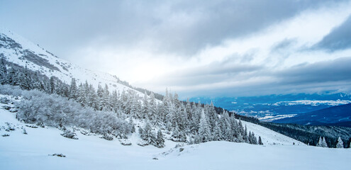 Scenic landscape of winter mountain range under cloudy sky