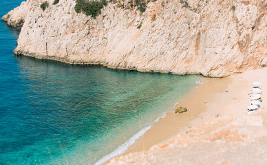 Summer scene with beautiful bay with blue sea water and yellow sand among the mountains. Vacation or holiday concept. Nature background with selective focus