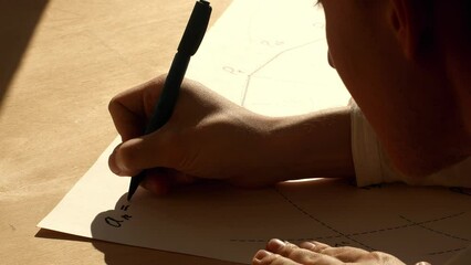 Young mathematician writes formula for polygon side length on the paper. Date of shooting day 2 March 2022 year, MSK time. This video was filmed in Russia.