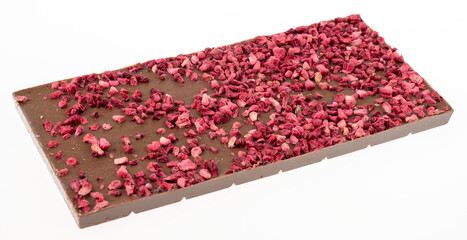 Milk chocolate with dried small raspberry pieces on light background. Close up image