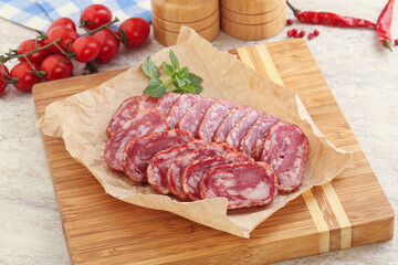 Sliced salami sausages over board