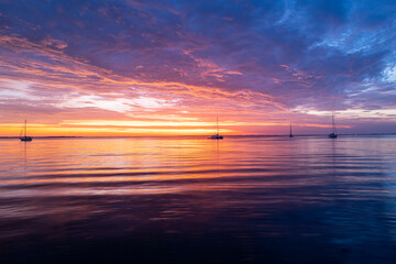 Sunset over sea with golden dramatic sky panorama. Calm sea with sunset sky. Ocean and sky background.