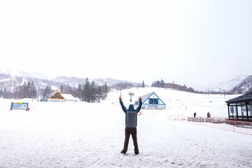 The man is standing and putting the hand into the air on the snow at Kiroro resort Sapporo,Hokkaido