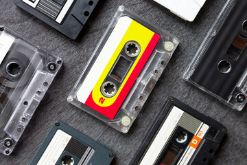 Top view of different old cassette tapes on dark gray background. Music icon of the 80s and 90s....