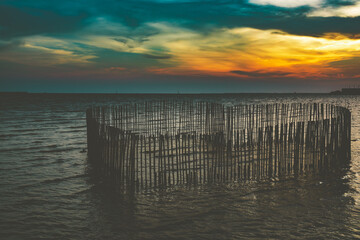 Sunset or evening time at sea or ocean at Bang poo, Samutprakan, Thailand. with bamboo shape of heart.