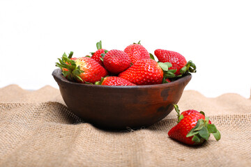 Ripe strawberries forest fruits in wooden bowl on  table. Fresh strawberry top view.