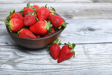 Ripe strawberries forest fruits in wooden bowl on  table. Fresh strawberry top view.