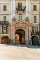 Fototapeta na wymiar Saluzzo, Cuneo, Italy - April 15, 2022: historic building with the Porta Santa Maria, gateway to the old city, con columns of Renaissance style with tympanum with the Savoy coat of arms