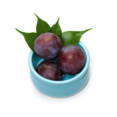 Plum fruit in blue bowl on white background