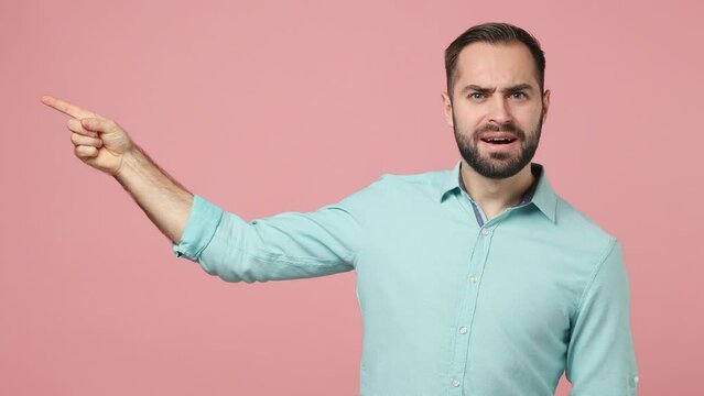 Nervous displeased irritated young brunet man 20s years old wears blue shirt looking pointing finger on camera you order expel say go away out of here isolated on plain plain pink background studio