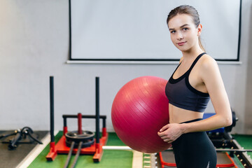 Sports woman holding fitness ball ready for exercising.