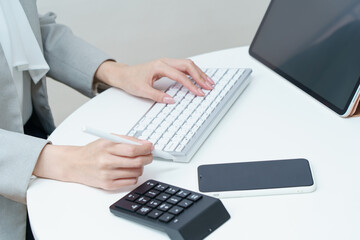 パソコンのキーボードを打つ女性の手元 