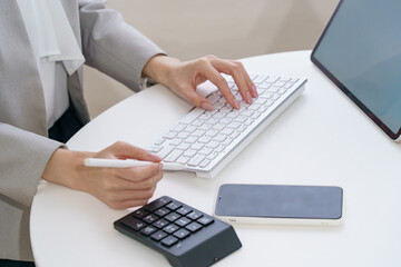 パソコンのキーボードを打つ女性の手元 