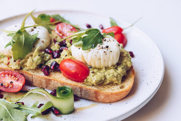 Poached eggs, avocado and cherry tomatoes on toast