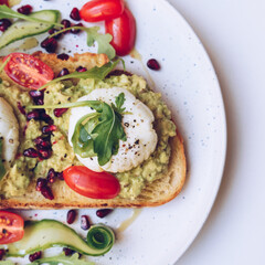 Poached eggs, avocado and cherry tomatoes on toast
