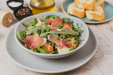 Salad with Prosciutto, olives and arugula. Cold snacks. Top view. 