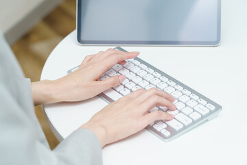 Fototapeta na wymiar パソコンのキーボードを打つ女性の手元 