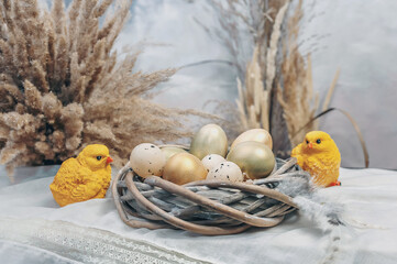 Composition of eggs in a nest and chickens on a light background