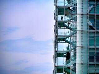 Fototapeta premium detail of unrecognizable men climbing the skyscraper stairs blank space for text