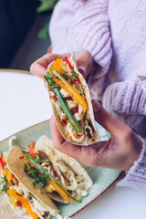 Close up of woman holding tacos.