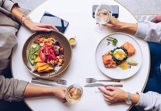 Two women friends having brunch in a restaurant, top view.