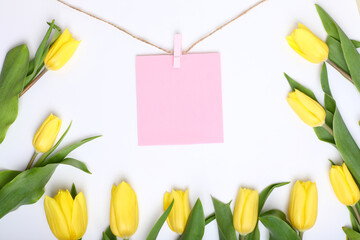 tulips with card, Spring composition. Delicate yellow tulips on white background top view space for...