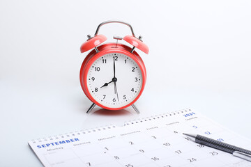 alarm clock with calendar. alarm clock with calendar on the background. Busy work reminder, annual leave, project deadline or memo text concept
