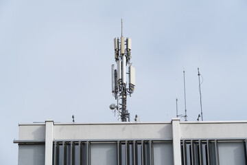 Antennen / Sender Funktelefon / Mobilfunk auf einem Gebäude in der Stadt (Handy-Sendemast) - cell