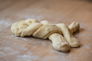 almost ready easter braid on a wooden worktop with wheat flour
