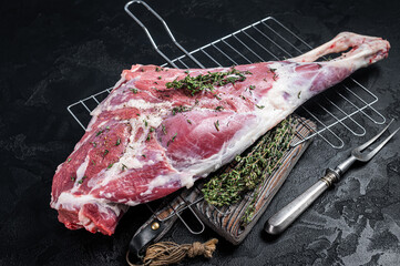 Marinated raw lamb mutton Leg Thigh with thyme and spices. Black background. Top view