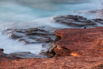 Rocky coast of Western Australia in Kalbarri National Park; long exposure image of heavy surf over the rocks
