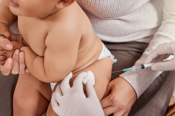 Itll only be a quick pinch. Shot of a little baby receiving an injection at the doctors office. © Lumeez I/peopleimages.com