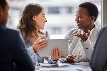 I understand exactly what you mean. Shot of two young businesswomen sitting together in the office and having a discussion while using a digital tablet.