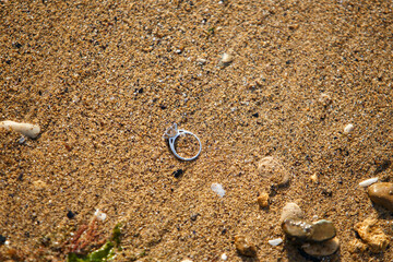 Fototapeta na wymiar Engagement ring on a beach sand