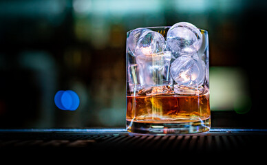 whiskey  and ice on glass in bar