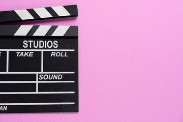 Fototapeta na wymiar movie clapper on pink table background ; film, cinema and video photography concept