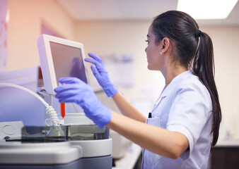 Supporting scientific research with state of the art equipment. Shot of a young scientist using a computer to conduct a medical test in a laboratory.